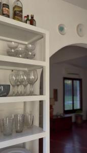 a shelf with wine glasses and bowls on it at Casa de Barro in Junín