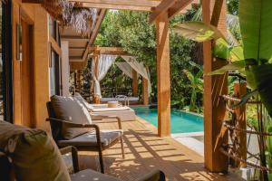 a patio with chairs and a swimming pool at Ma'oni Seascape Villas in Panglao Island