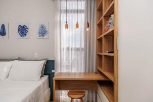 a bedroom with a bed and a desk next to a book shelf at Apartamento ensolarado em condomínio clube in Curitiba +38 photos