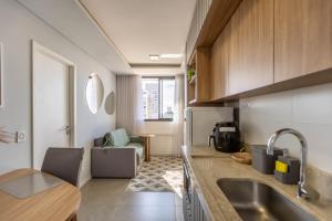 a kitchen with a sink and a counter top at Apartamento ensolarado em condomínio clube in Curitiba