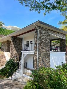 a brick house with stairs and a balcony at Bungles Ungalow in Castries