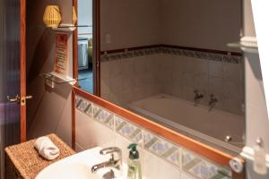 a bathroom with a sink and a bath tub at Aston Norwood Chalets in Upper Hutt