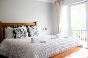 a bedroom with a bed with pillows and a window at Aston Norwood Chalets in Upper Hutt
