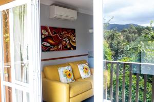 a living room with a couch and a balcony at Aston Norwood Chalets in Upper Hutt