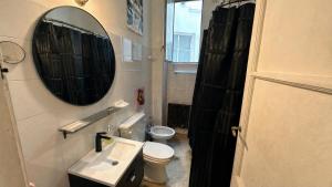 a bathroom with a toilet and a sink and a mirror at Home lab studio in Córdoba +24 photos
