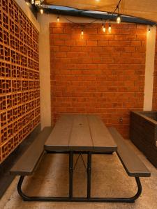 a picnic table in a room with a brick wall at El Suburbio - Aldama in Morelia