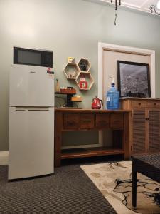 a kitchen with a white refrigerator and a wooden table at Alexandra Hotel in Pirongia