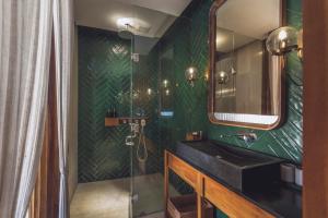a green bathroom with a sink and a mirror at Monolocale Resort & Spa Seminyak by Ini Vie Hospitality in Seminyak +34 photos