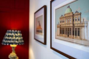 a picture of a building on a wall next to a lamp at High Street Hideaway Cheltenham in Cheltenham