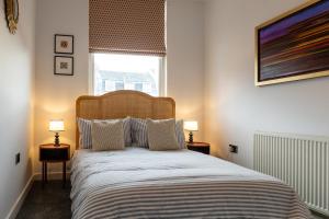 a bedroom with a bed with two lamps on tables at High Street Hideaway Cheltenham in Cheltenham +27 photos