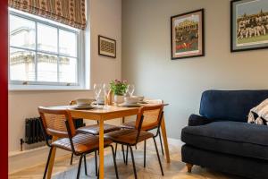 a dining room table with chairs and a couch at High Street Hideaway Cheltenham in Cheltenham