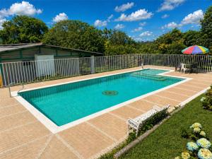 a swimming pool with a fence and an umbrella at Hostal LA MIA in Armenia