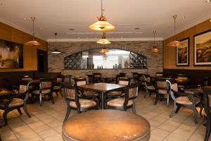 a restaurant with tables and chairs and a bar at フォレストヒルズガーデン in Mihara