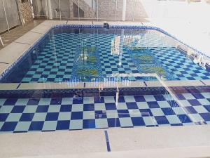 a swimming pool with a blue and white checkered floor at Hotel El Escorpión in Melgar