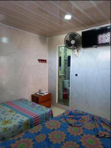 a bedroom with a bed and a fan on the wall at Hotel El Escorpión in Melgar