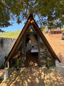 a bedroom in a triangular shaped house with a roof at Chalé refugio de Igaratá in Igaratá