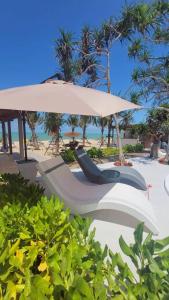 a chair under an umbrella on the beach at Sunrio Beach Hotel Sichon in Ban Plai Thon
