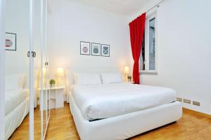 ローマにあるCozy Borgo - My Extra Homeの白いベッドと赤いカーテンが備わる白いベッドルーム1室