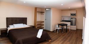 a bedroom with a large bed and a small kitchen at Gran Estancia Vallecito in Arequipa