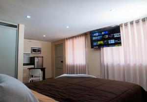 a bedroom with a bed and a television on the wall at Gran Estancia Vallecito in Arequipa