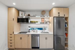 a kitchen with wooden cabinets and a stainless steel refrigerator at Hotel SOMA in Fort Worth