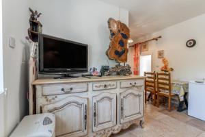 a tv on top of a wooden cabinet in a room at L'atelier de Raymond in Verfeuil