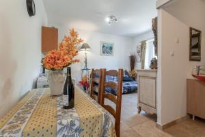 a dining room table with a vase of flowers on it at L'atelier de Raymond in Verfeuil
