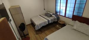a small bedroom with two beds and a window at Hostal LA MIA in Armenia