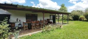 a house with a table and chairs in a yard at Hostal LA MIA in Armenia