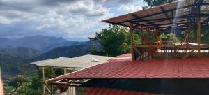 a building with a roof with mountains in the background at La TOLVA Café & experiencia in Pijao +23 photos
