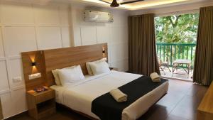 a bedroom with a large bed and a balcony at Bellavista Resort Munnar in Munnar +58 photos