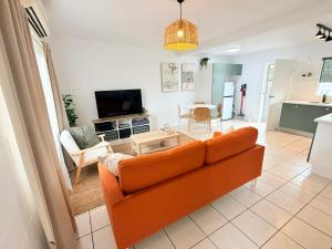 a living room with an orange couch and a table at 'Your Place on Davidson' Uno in Mount Isa