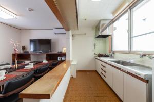 a large kitchen with a long table and a sink at Daini Kuwamura Building 4th in Tokyo