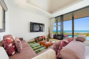 a living room with a couch and a table at Villa Baan Saitara in Lamai