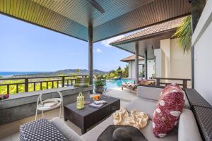 an outdoor patio with a couch and a table at Villa Baan Saitara in Lamai
