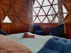 a room with a bed and two chairs and a window at Glamping Centauro in Tota
