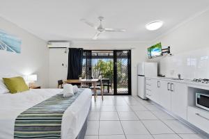 a white bedroom with a bed and a kitchen at Ingenia Holidays Hervey Bay in Hervey Bay