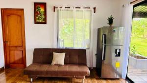 a living room with a couch and a refrigerator at Rio Celeste Birds Garden Apartments with air conditioning and Wifi Starlink in Upala