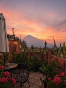 a patio with a view of a mountain at sunset at Mazaryk Bed and Breakfast in Antigua Guatemala
