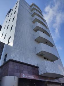 a white building with balconies on the side of it at HOTEL GLOBAL VIEW Morioka in Morioka