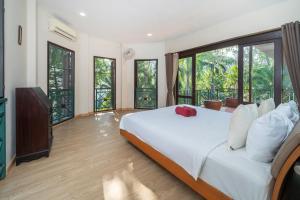 a bedroom with a large bed and large windows at Nature's Hill side Phana House in Phuket +22 photos