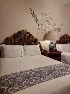 a bedroom with a bed with a flower on the wall at Hacienda de las Flores in San Miguel de Allende