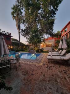 a patio with a pool and chairs and umbrellas at Hacienda de las Flores in San Miguel de Allende