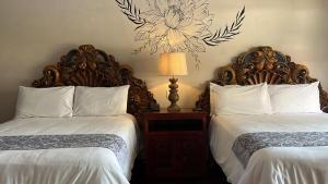 a bedroom with two beds and a lamp on a table at Hacienda de las Flores in San Miguel de Allende