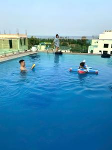 two children playing in the water in a swimming pool at Bamboo Hotel FLC Sầm Sơn in Sầm Sơn