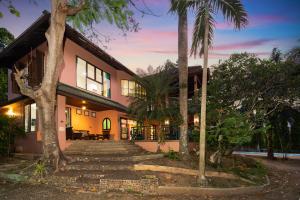 a house with palm trees in front of it at Nature's Hill side Phana House in Phuket