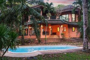 a house with a swimming pool in front of it at Nature's Hill side Phana House in Phuket
