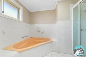 a bath tub in a white bathroom with a window at 3B house Central Coast parking in Blue Haven