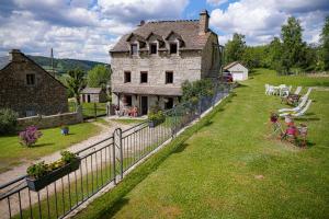 an old house with a fence in front of it at Gîte le marlet in Saint-Alban-sur-Limagnole