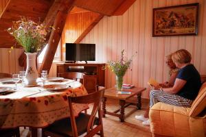 two women sitting in a living room with a table at Gîte le marlet in Saint-Alban-sur-Limagnole